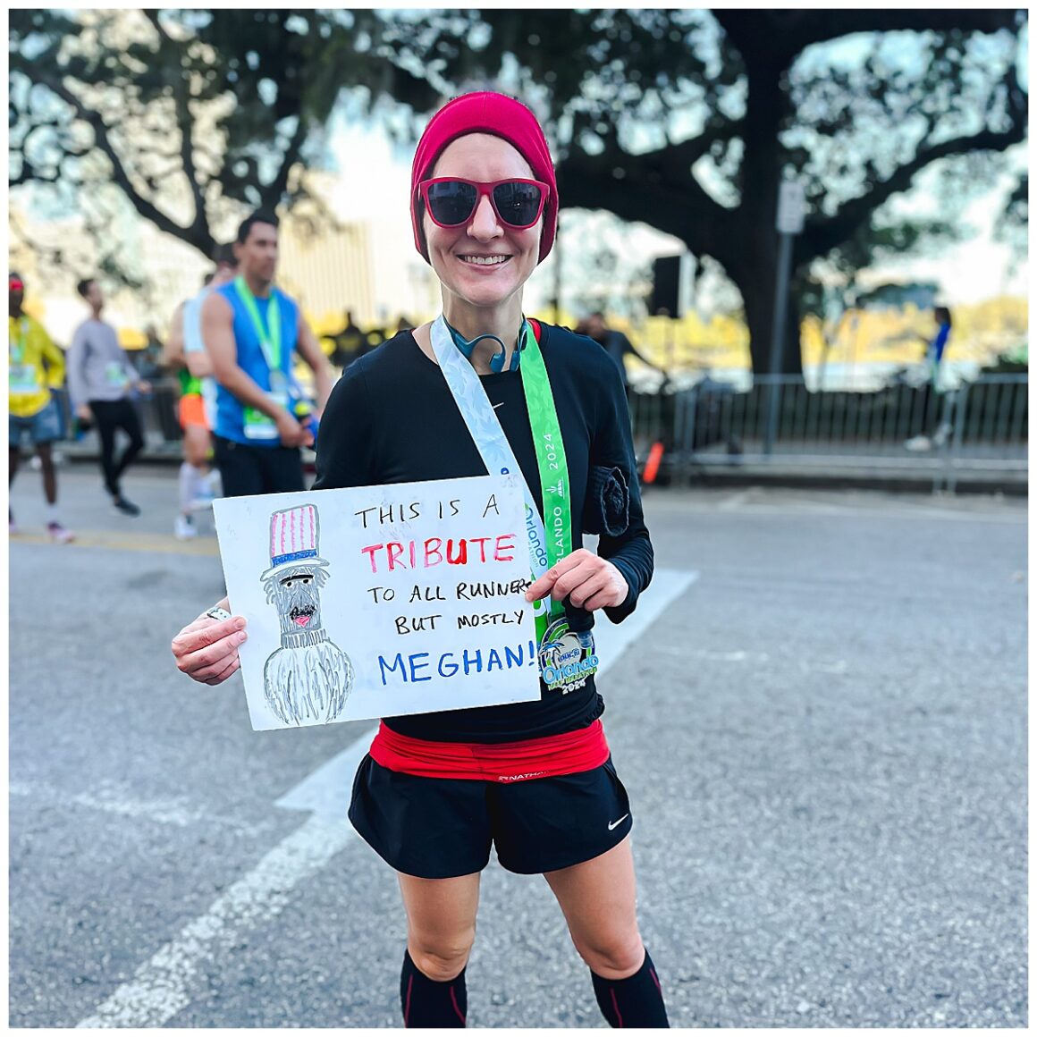 Fall running and 4 reasons to fall in love with it. Girl standing at a finish line of a half marathon wearing a medal.